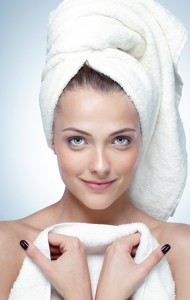 Closeup portrait of a happy woman with perfect skin and towel on head